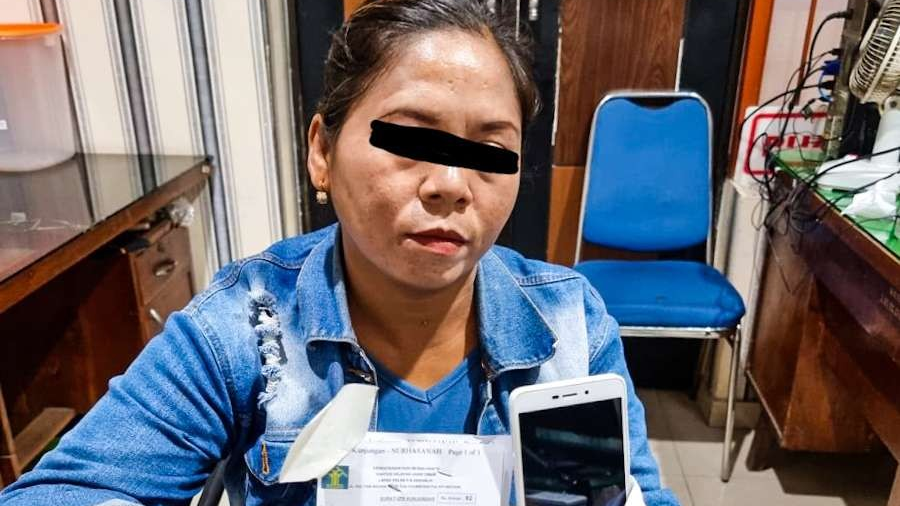 Perempuan yang membawa nasi bungkus berlauk handphone untuk suaminya yang lagi mendekam di Lapas Sidoarjo. (Foto: Aini Arifin/Ngopibareng.id)