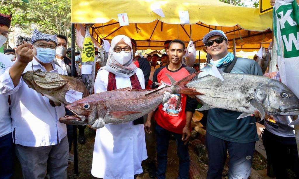 Bupati Banyuwangi Ipuk Fiestiandani memegang ikan hasil tangkapan peserta Fishing Festival di kawasan Pantai Grajagan, Kecamatan Purwoharjo, Banyuwangi, Jawa Timur. (Foto: Humas Pemkab Banyuwangi)