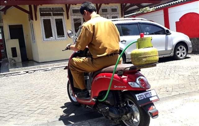 ASN Bondowoso mencoba sepeda motor berbahan bakar gas elpiji 3 kg inovasi siswa SMK PGRI 2 Bondowoso.(Foto: Guido Saphan/Ngopibareng.id)