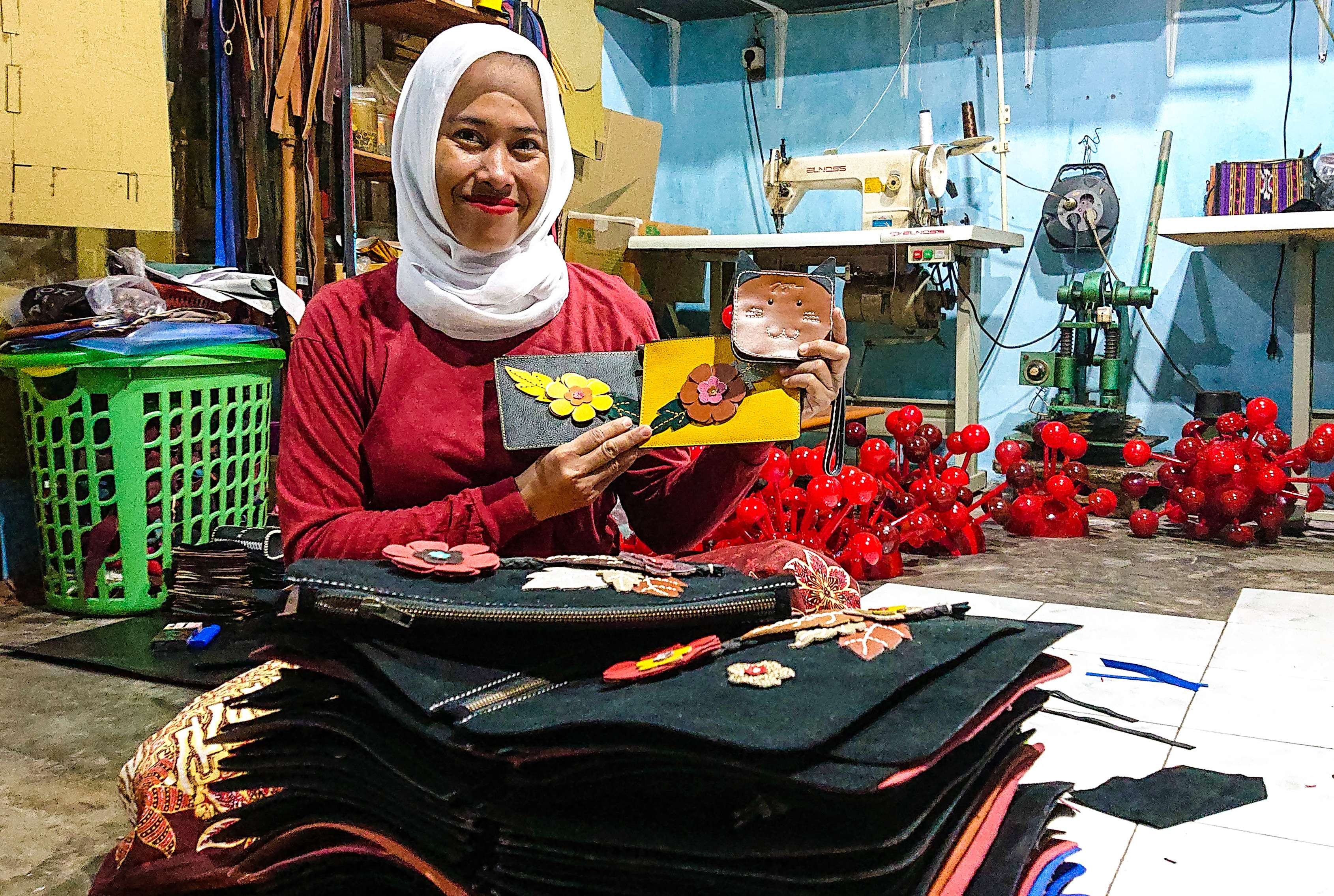 Dewi Bralin sedang menunjukkan dompet Joger buatannya. (Foto: Aini Arifin/Ngopibareng.id)