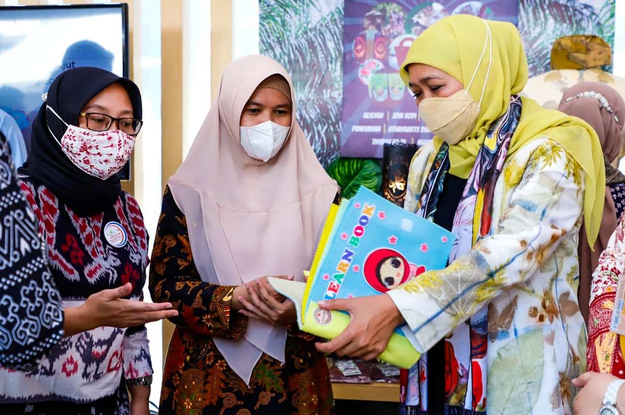 Gubernur Jawa Timur Khofifah Indar Parawansa (hijab kuning) membagikan buku kepada peserta UMKM (Foto: Aini/Ngopibareng.id)