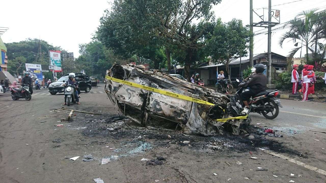 Mobil yang terbakar di depan Stadion Kanjuruhan, Kabupaten Malang, Minggu 2 Oktober 2022. (Foto: Dyah Ayu Pitaloka/Ngopibareng.id)