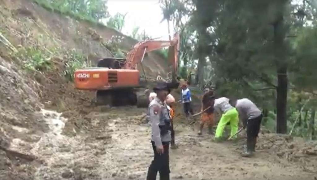 Petugas gabungan sedang membersihkan longsoran yang menimbun jalan di Kecamatan Bendungan, Trenggalek. (Foto: Ant)