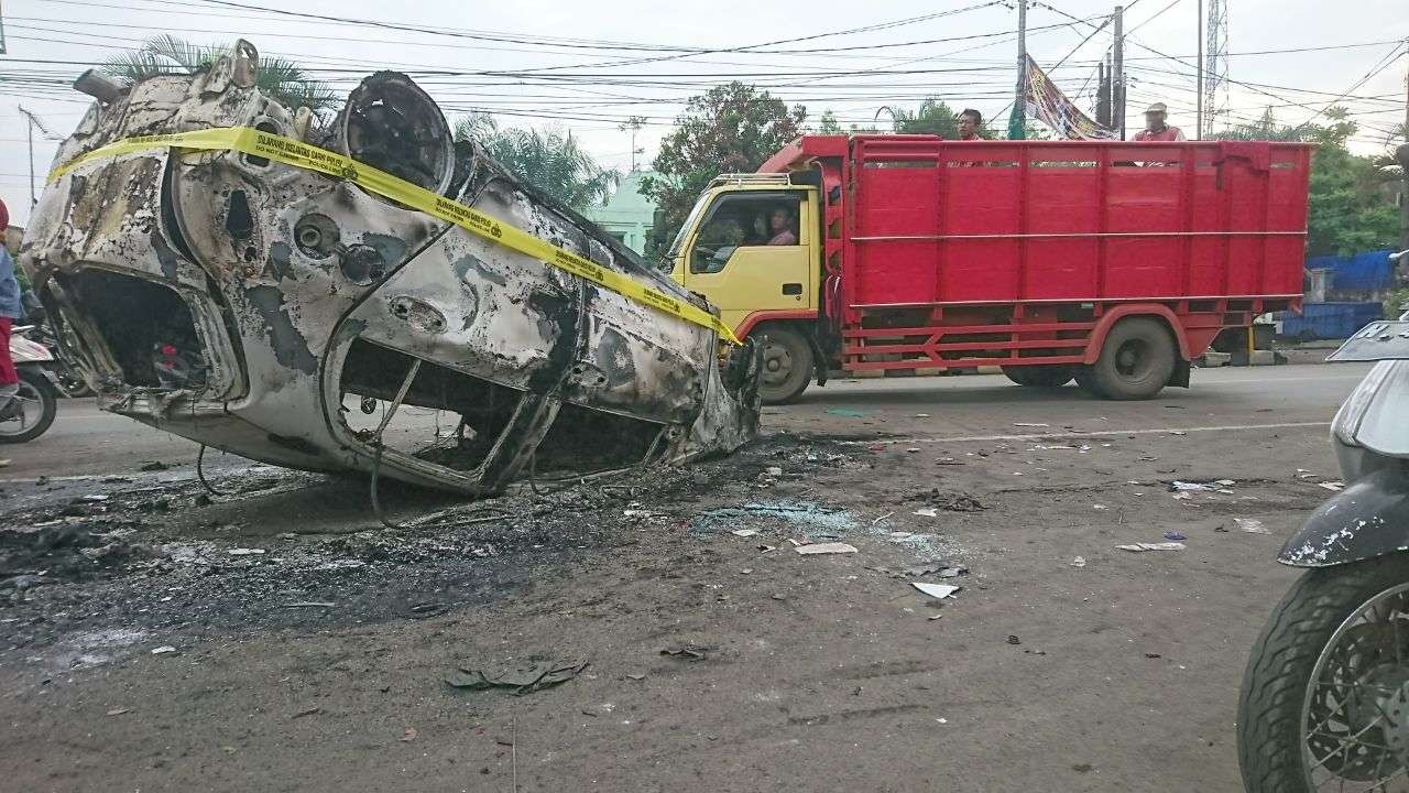 Mobil polisi yang hangus terbakar di depan Stadion Kanjuruhan, Minggu 2 Oktober 2022. (Foto: Dyah Ayu Pitaloka/Ngopibareng.id)