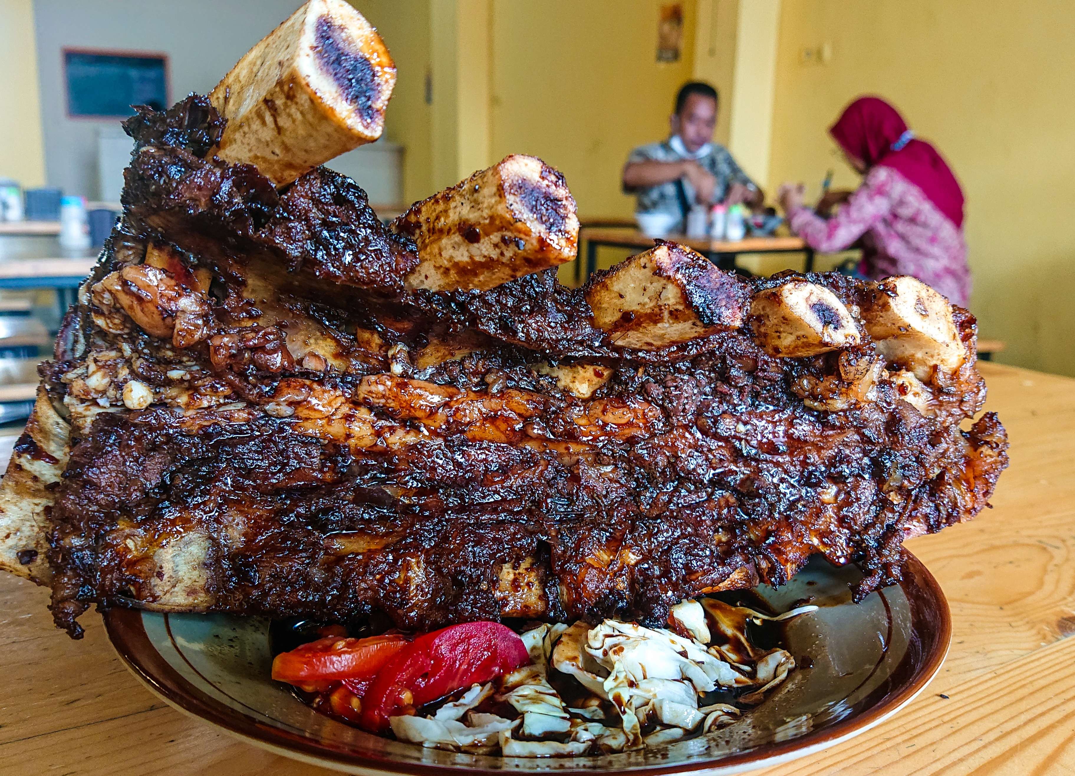 Iga bakar dino jumbo di kedai balungan dinosaurus. (Foto: Aini Arifin/Ngopibareng.id)