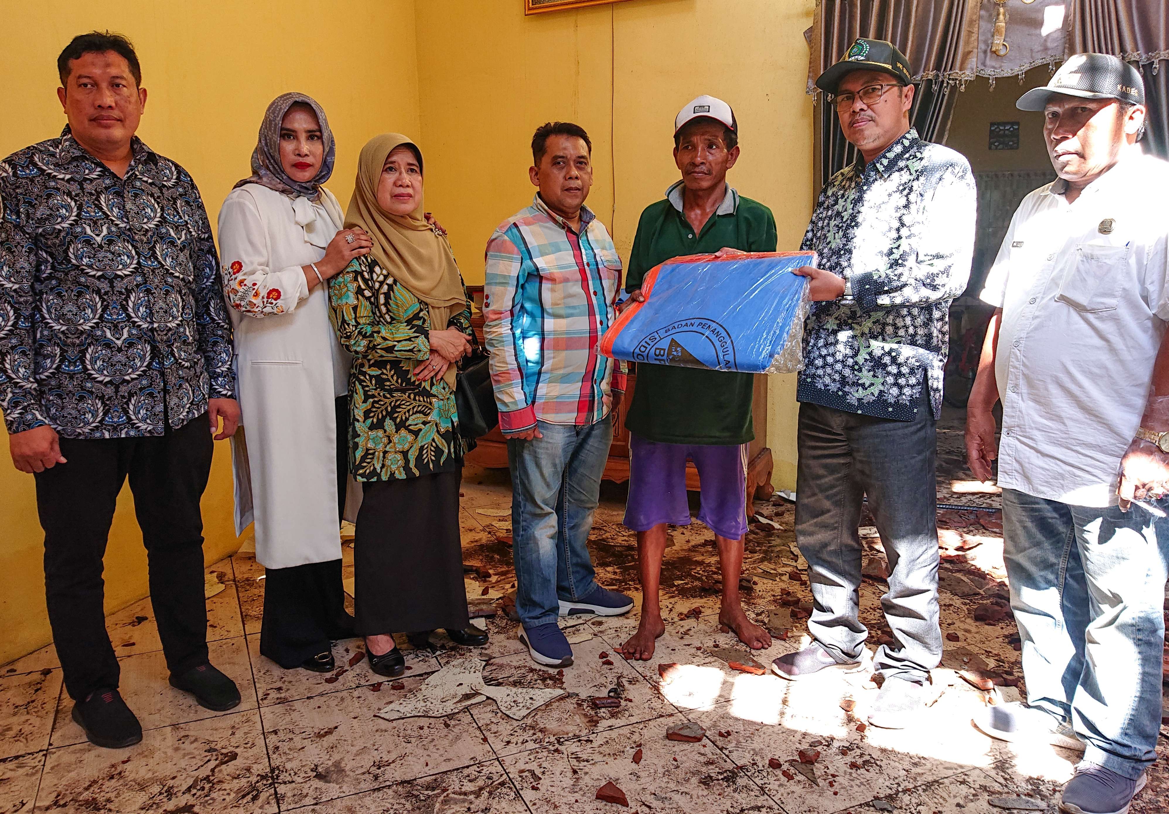 Korban bencana puting beliung (kaos hijau) mendapat bantuan material dari DPRD Sidoarjo (foto : Aini/Ngopibareng.id)