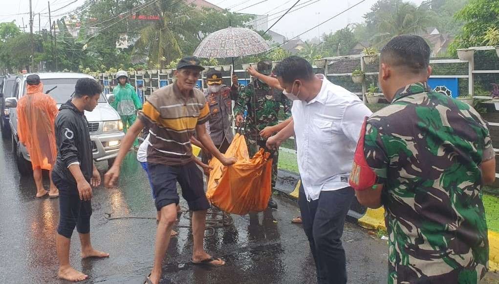 Petugas mengevakuasi jenazah pria tanpa identitas dari bawah jembatan (foto;istimewa)