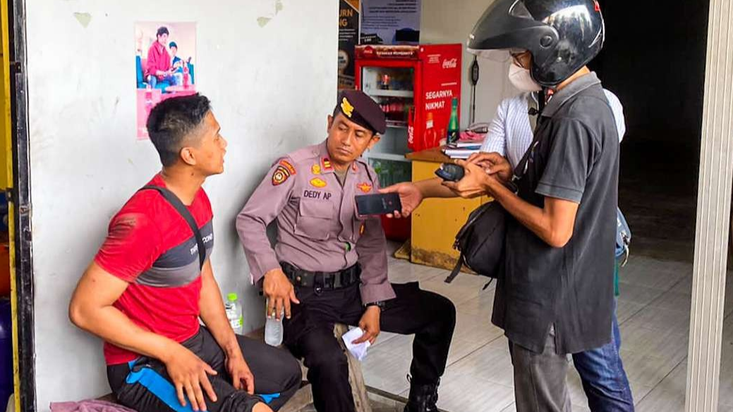 Bripda Ilham (kaos merah) saat dimintai keterangan polisi (foto : Aini/Ngopibareng.id)