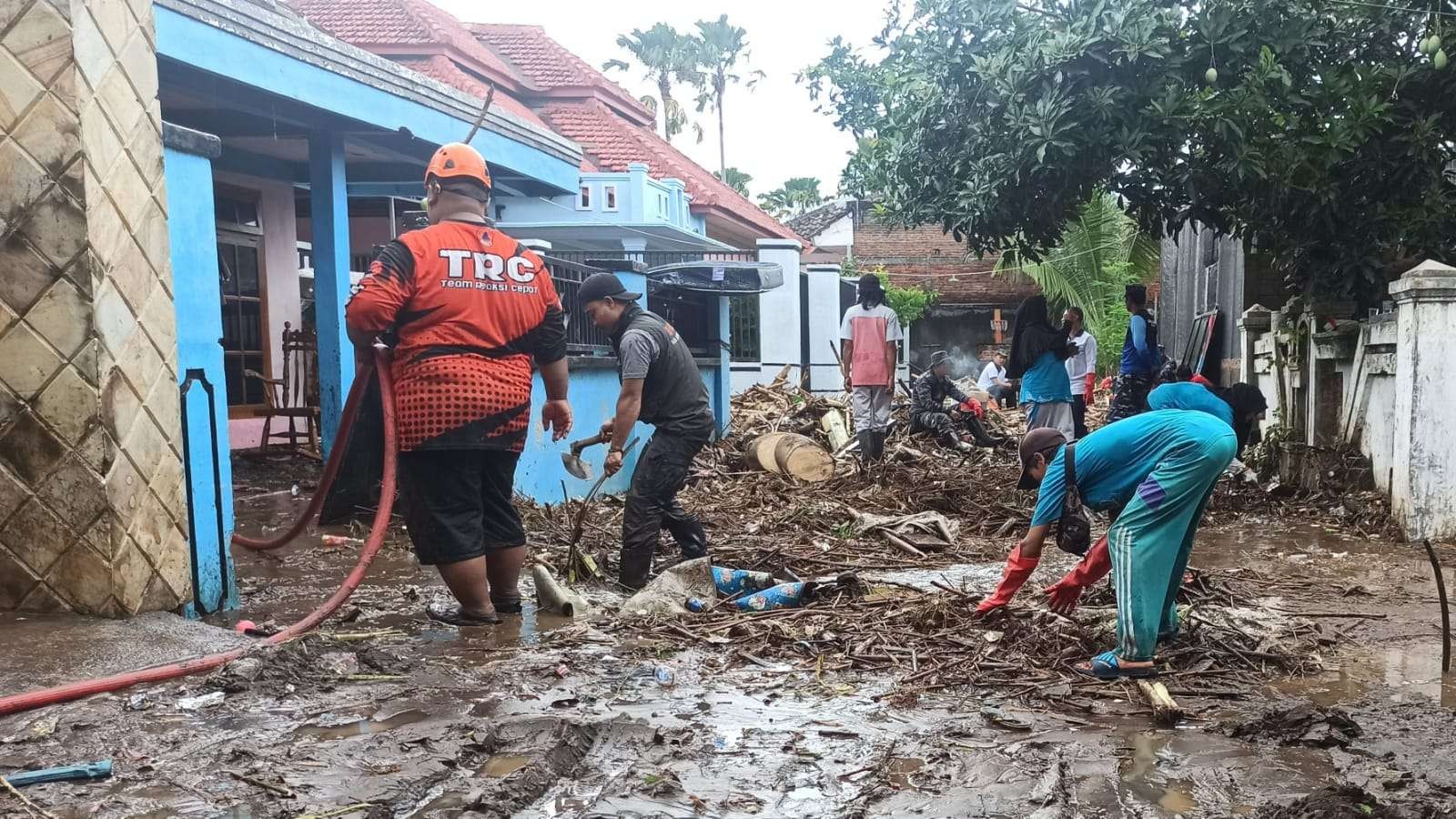 Proses pembersihan sampah di sekitar lokasi banjir di kawasan Sutri, Kelurahan Sobo, Banyuwangi. (Foto: Muh Hujaini/Ngopibareng.id)