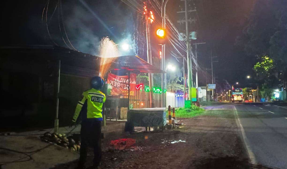 Anggota Satlantas Polresta Banyuwangi berusaha memadamkan api yang melalap atap rumah warga. (Foto: Polresta Banyuwangi)