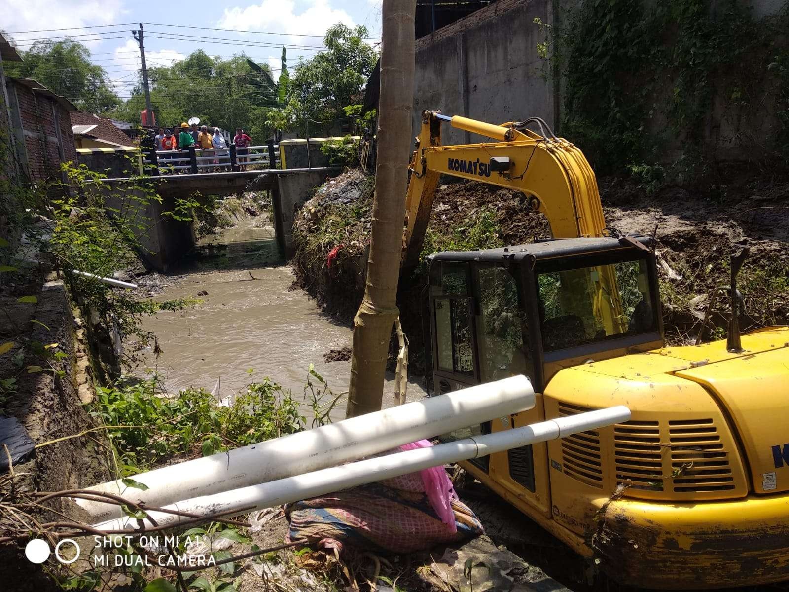 Alat berat diterjunkan keruk lumpur dan sampah di saluran irigasi Cepu. (Foto: Ahmad Sampurno/Ngopibareng.id)