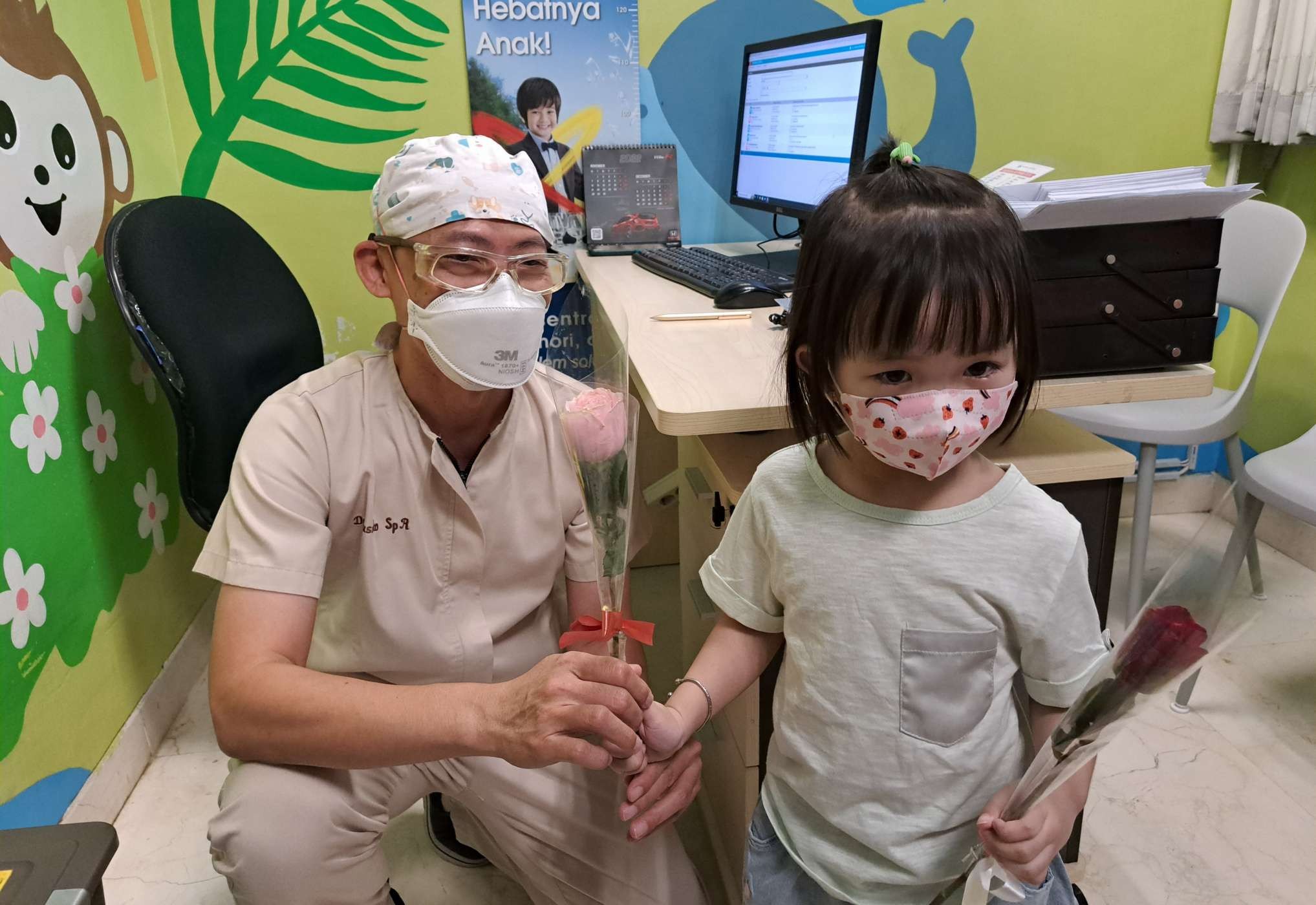 Dokter Susanto, spesialis anak National Hospital Surabaya saat diberi bunga oleh seorang pasien anak dalam rangka Hari Dokter Nasional. (Foto: Pita Sari/Ngopibareng.id)