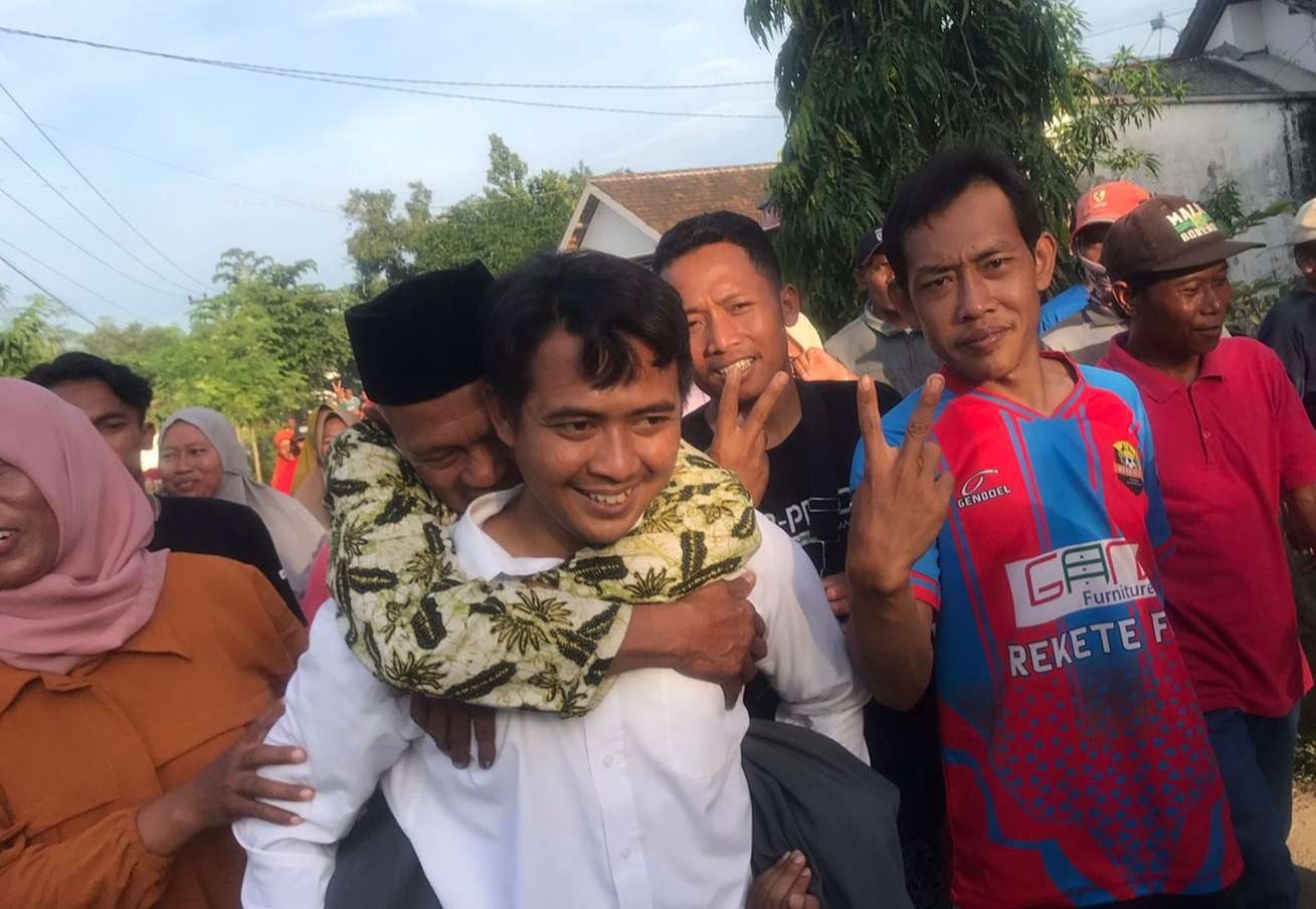 Kades terpilih, Ahmad Roziqin saat menggendong ayahnya, usai perhitungan surat suara. (Foto: Dokumentasi warga Sumurgung)