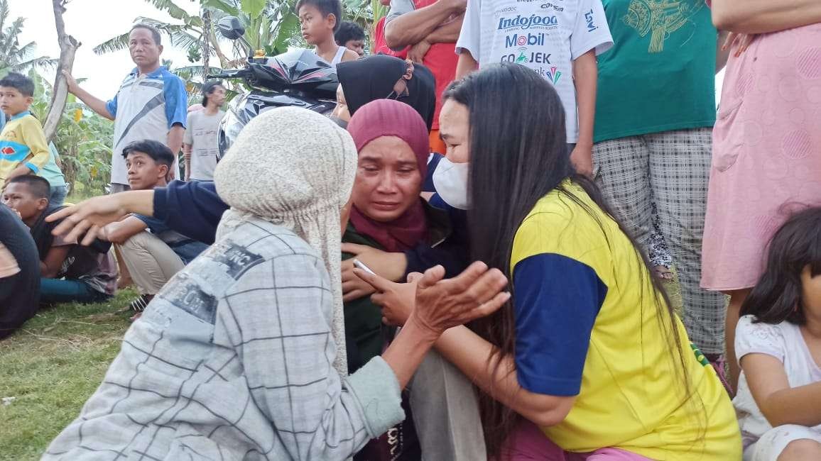 Ibu Nanik (tengah), orang tua korban bocah hanyut di Pantai Sukowidi, Banyuwangi, ditenangkan oleh beberapa keluarganya, saat menanti kabar putranya. (Foto: Muh Hujaini/Ngopibareng.id)