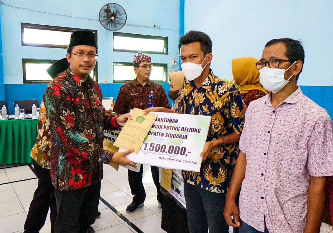 Bupati Sidoarjo Ahmad Muhdlor Ali atau Gus Muhdlor menyerahkan bantuan kepada guru korban bencana angin puting beliung. (Foto: Aini Arifin/Ngopibareng.id)