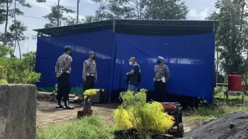 Petugas kepolisian berjaga di depan lokasi pelaksanaan autopsi di Tempat Pemakaman Umum Dusun Patuk, Desa Sukolilo, Kecamatan Wajak, Kabupaten Malang, Jawa Timur. (Foto: Ant)