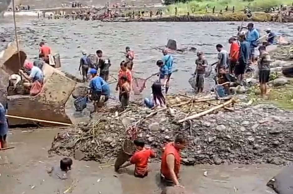 Masyarakat ramai-ramai mencari ikan ke Bendungan Sampean Tapen yang dikuras. (Foto: Guido Saphan/Ngopibareng.id)