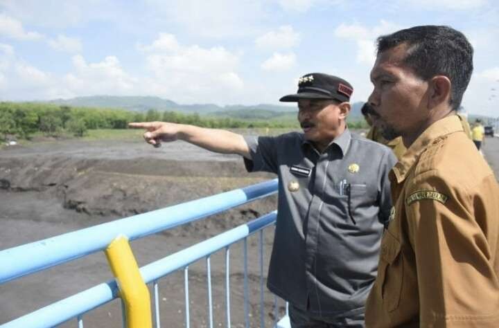 Bupati  Situbondo, Karna Suswandi meninjau Bendungan Sampean Baru Bondowoso yang dalam proses pengurasan. (Foto: Guido Saphan/Ngopibareng.id)