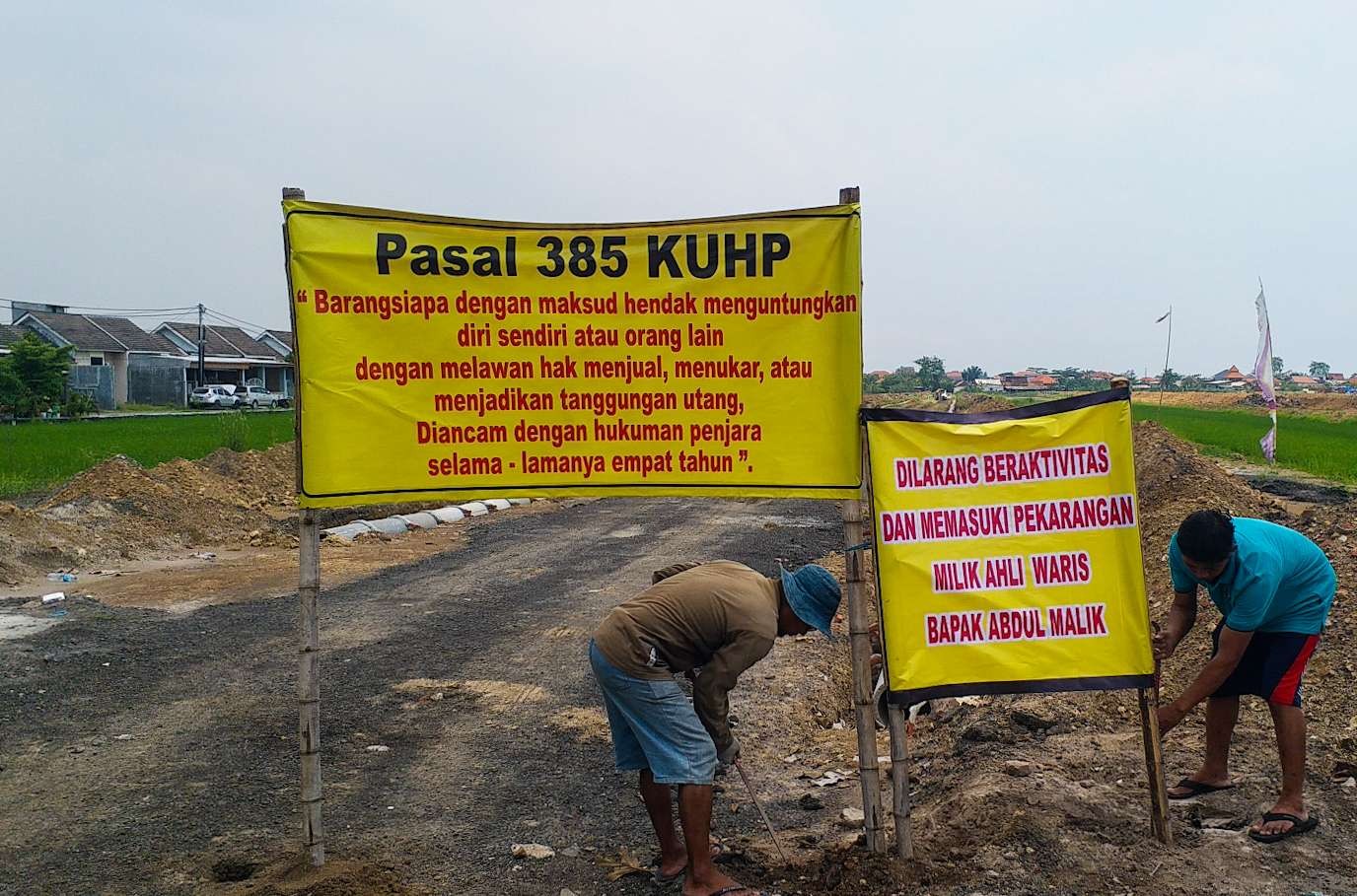 Petani Nurul Kirom selaku pemilik sawah menancapkan baliho di atas tanah urukan. Pihak pengembang Diamond Village Juanda, Sidoarjo, Jawa Timur, tak lunasi pembayaran. (Foto: Aini Arifin/Ngopibareng.id)