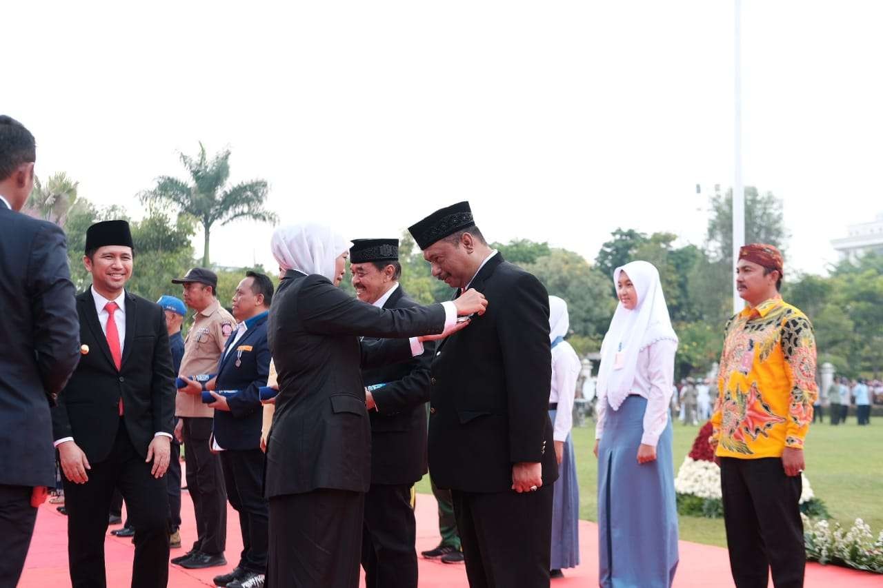 Gubernur Jatim, Khofifah Indar Parawansa saat memasang lencana Jer Basuki Mawa Beya kepada Ketua KONI Jatim, M Nabil dalam Upacara Peringatan Hari Pahlawan di Tugu Pahlawan, Surabaya, Kamis 10 November 2022. (Foto: KONI Jatim)