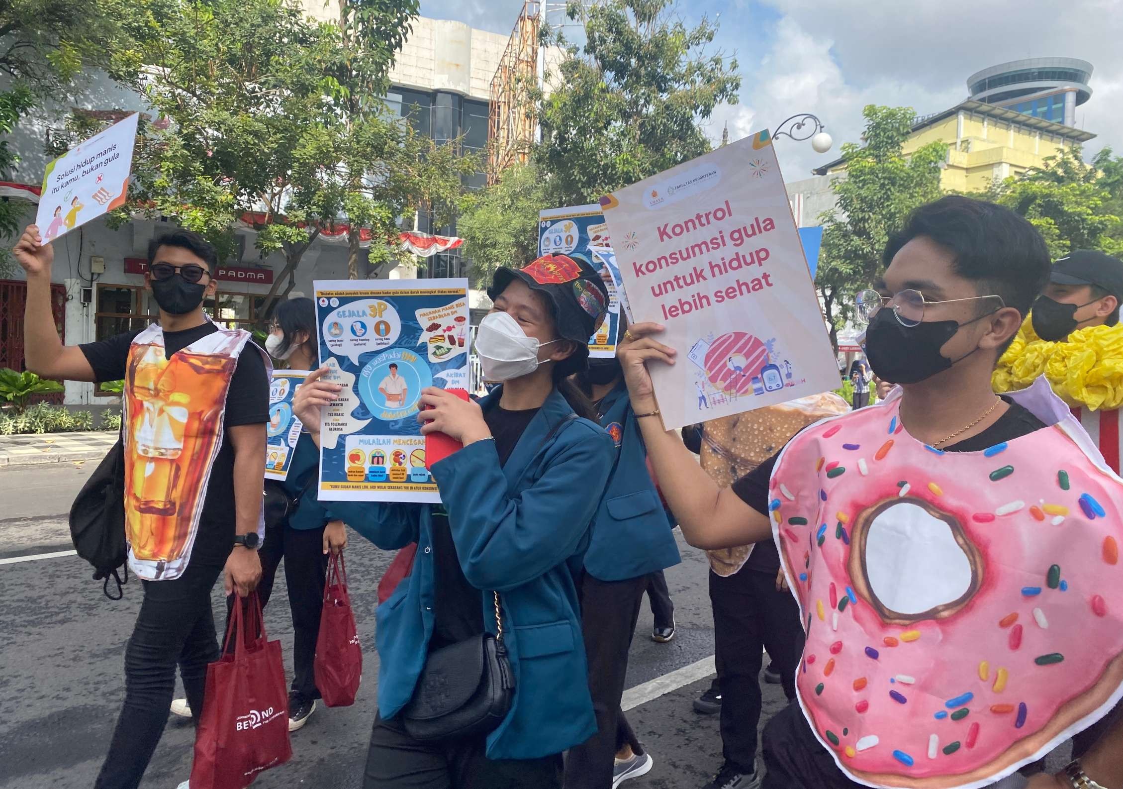 Mahasiswa Ubaya sambil mengenakan kostum makanan manis lakukan kampanye bahaya diabetes di CFD Tunjungan. (Foto: Humas Ubaya)