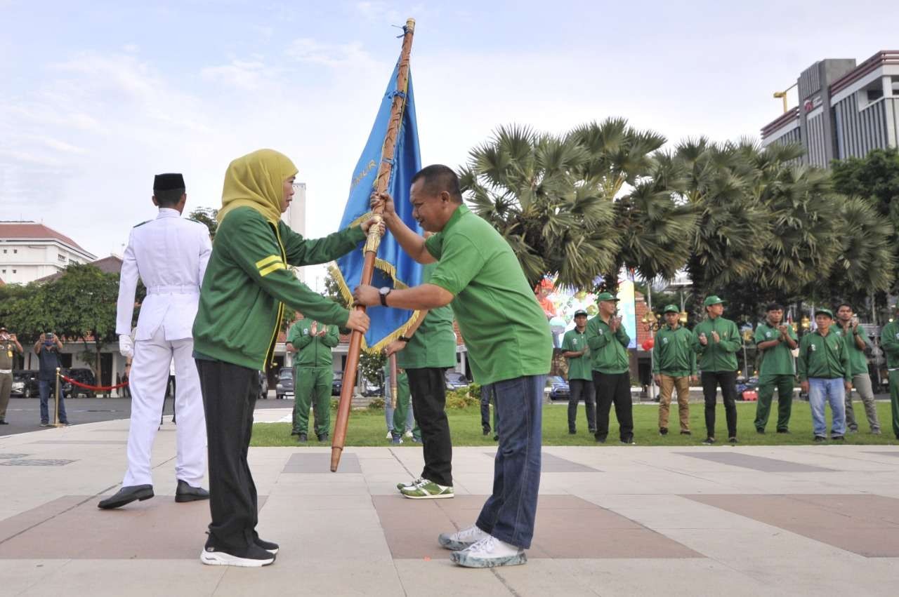 Gubernur Jatim, Khofifah Indar Parawansa menyerahkan pataka PWI Jatim kepada Ketua PWI Jatim Lutfil Hakim dalam pelepasan kontingen Jatim untuk Porwanas 2022 di Gedung Negara Grahadi, Surabaya, Sabtu 19 November 2022. (Foto: PWI Jatim)