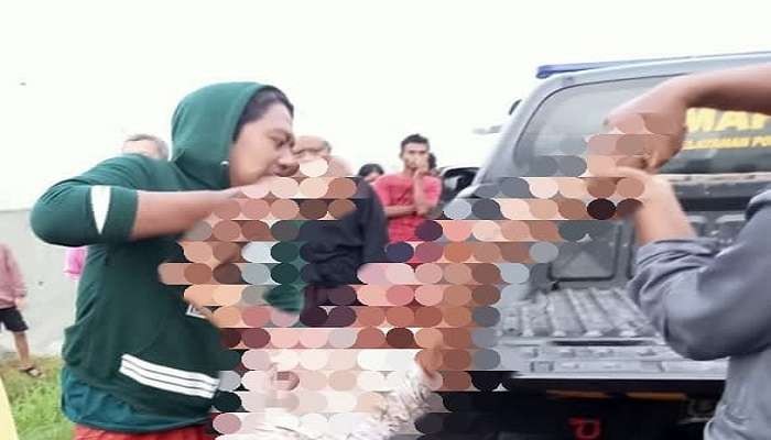 Polisi dibantu beberapa warga saat menaikkan korban ke atas mobil (Foto: Istimewa)