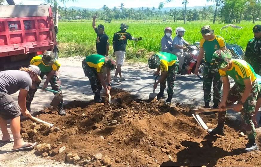 Warga bersama anggota TNI menambal jalan rusak dan berlubang di Kecamatan Nangkaan Bondowoso. (Foto: Guido Saphan/ngopibareng.id)