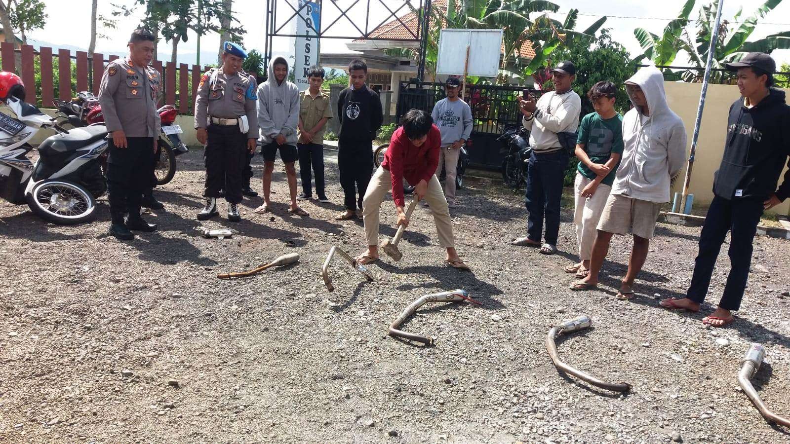 Satu persatu knalpot brong hasil razia dimusnahkan dengan cara ditempa  (foto: istimewa)