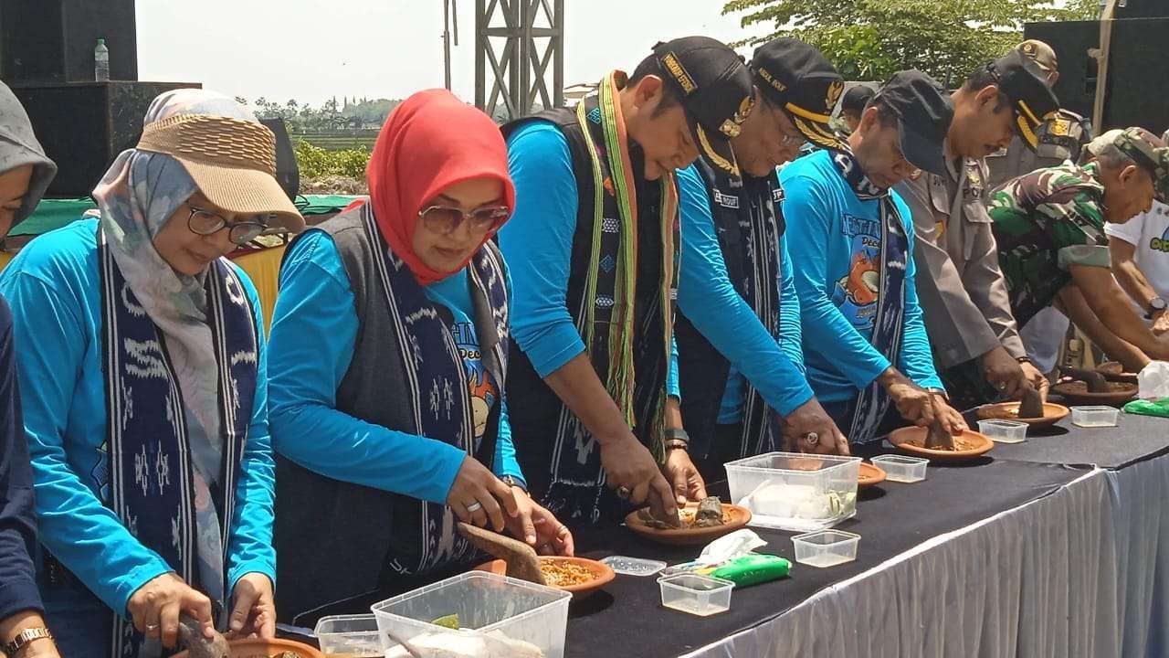 Keterangan Foto: Bupati Yuhronur Efendi didampingi istri dan Wabup Abdu Rouf sedang ngulek sambel pecel lele (Foto:Imron Rosidi/ngopibareng.id)