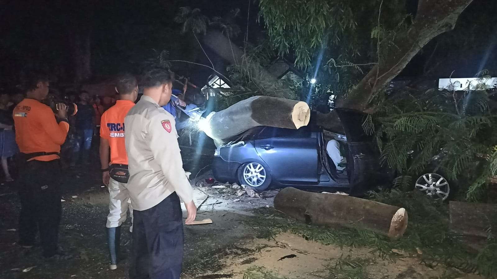 TRC BPBD Jember bersama anggota Polsek Patrang dan beberapa warga saat membantu proses evakuasi korban dan pohon tumbang. (Foto: Dokumentasi Polsek Patrang)