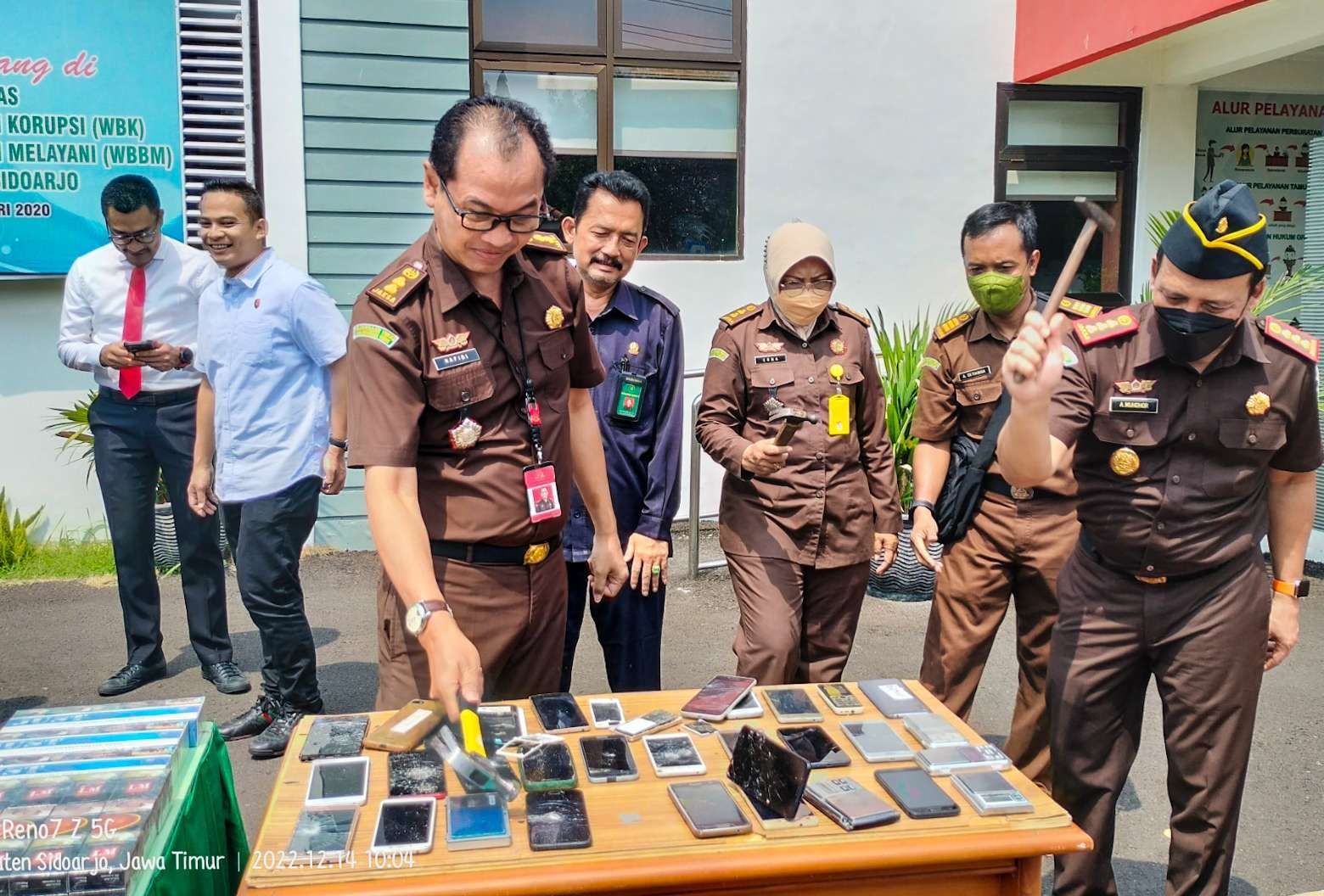 Kajari Sidoarjo memusnahkan barang bukti HP menggunakan palu (Foto : Aini/Ngopibareng.id)