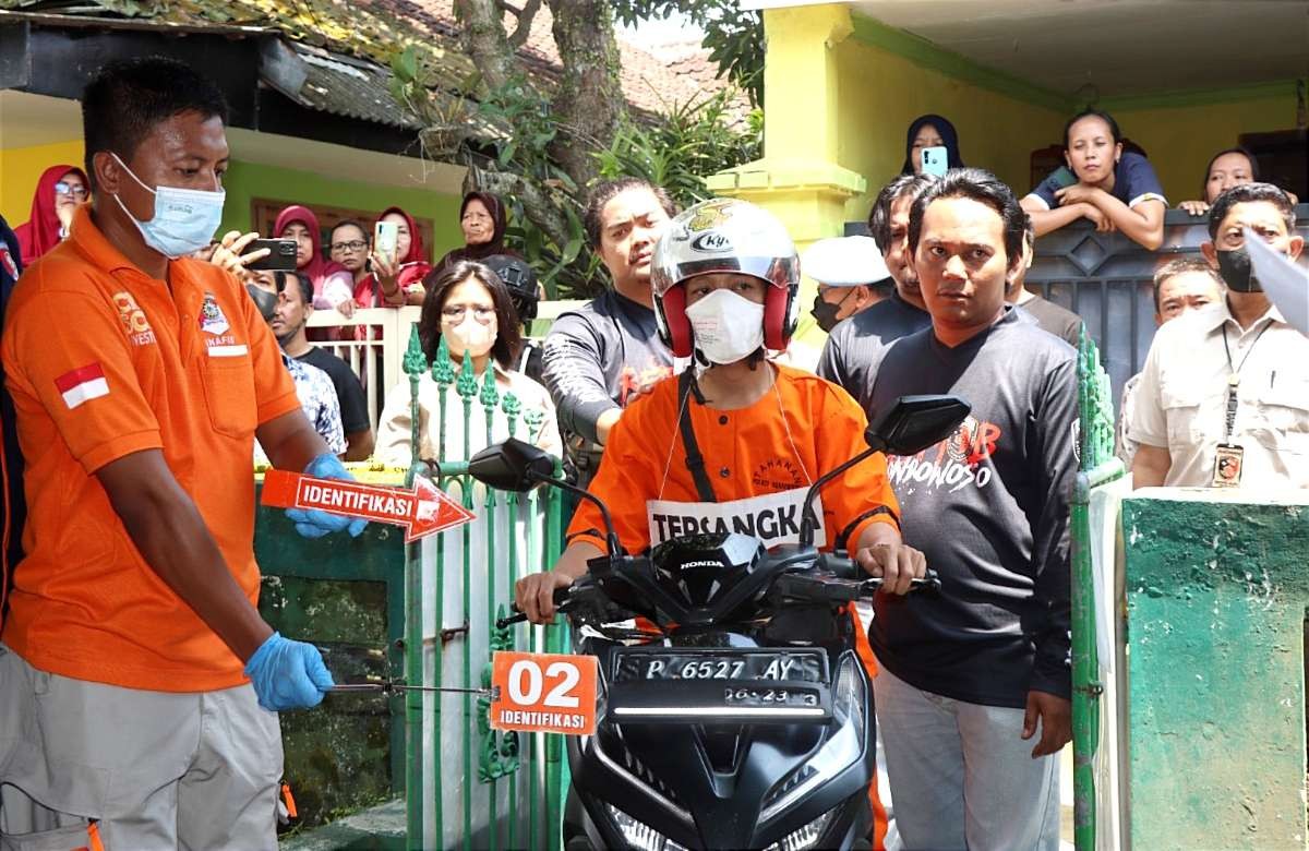 Tersangka pembunuhan ojol saat menjalani adegan konstruksi di TKP, Kamis 15 Desember 2022.(foto:guido saphan/ngopibareng.id)