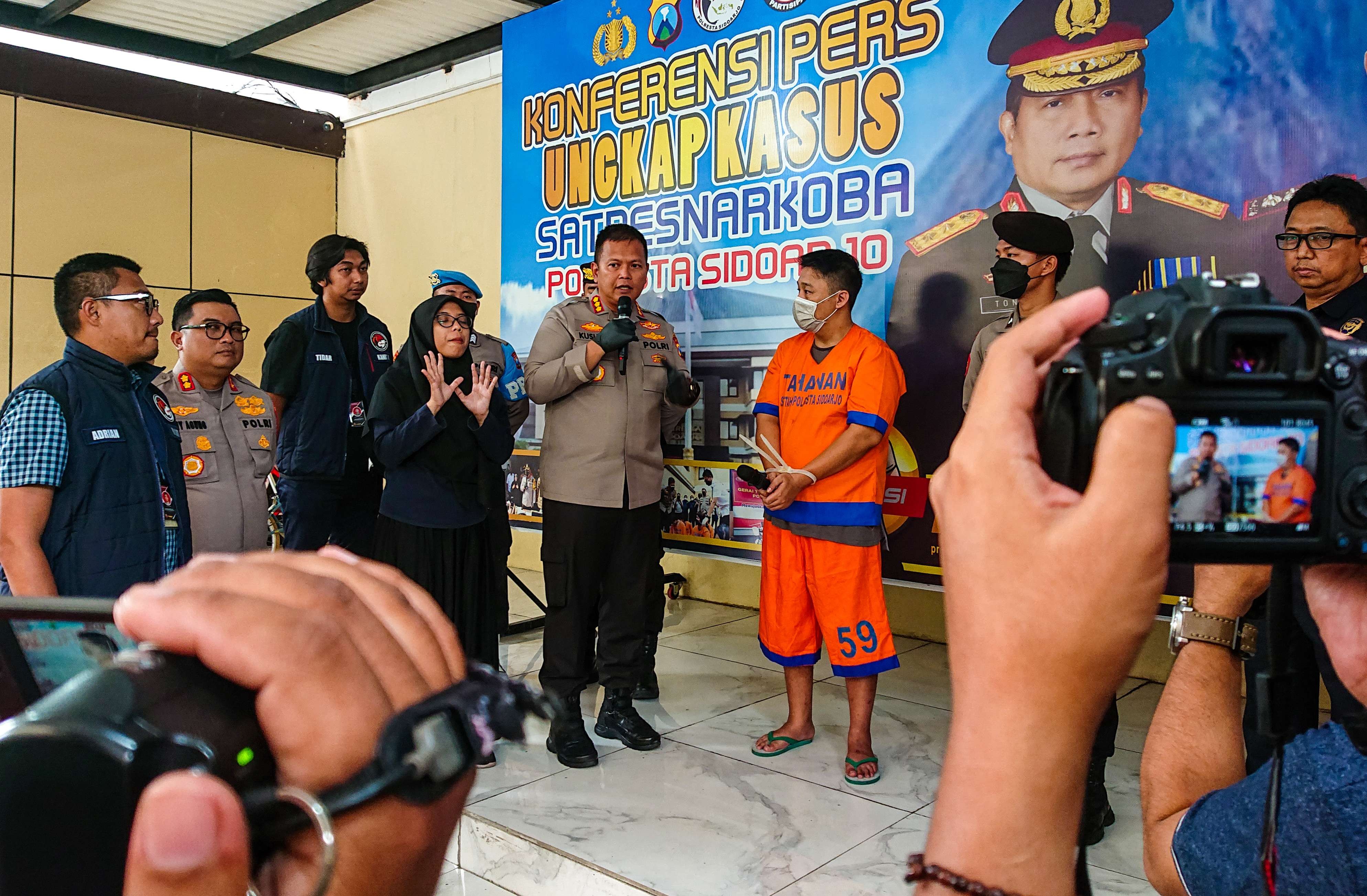 Tersangka driver ojol pembuat ekstasi saat diinterogasi Kapolresta Sidoarjo. (Foto: Aini/Ngopibareng.id)