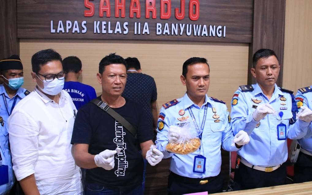 Kepala Lapas Banyuwangi Wahyu Indarto (tengah) menunjukkan barang bukti sabu dengan latar belakang AK dan SA, pelaku penyelundupan sabu (foto:istimewa)