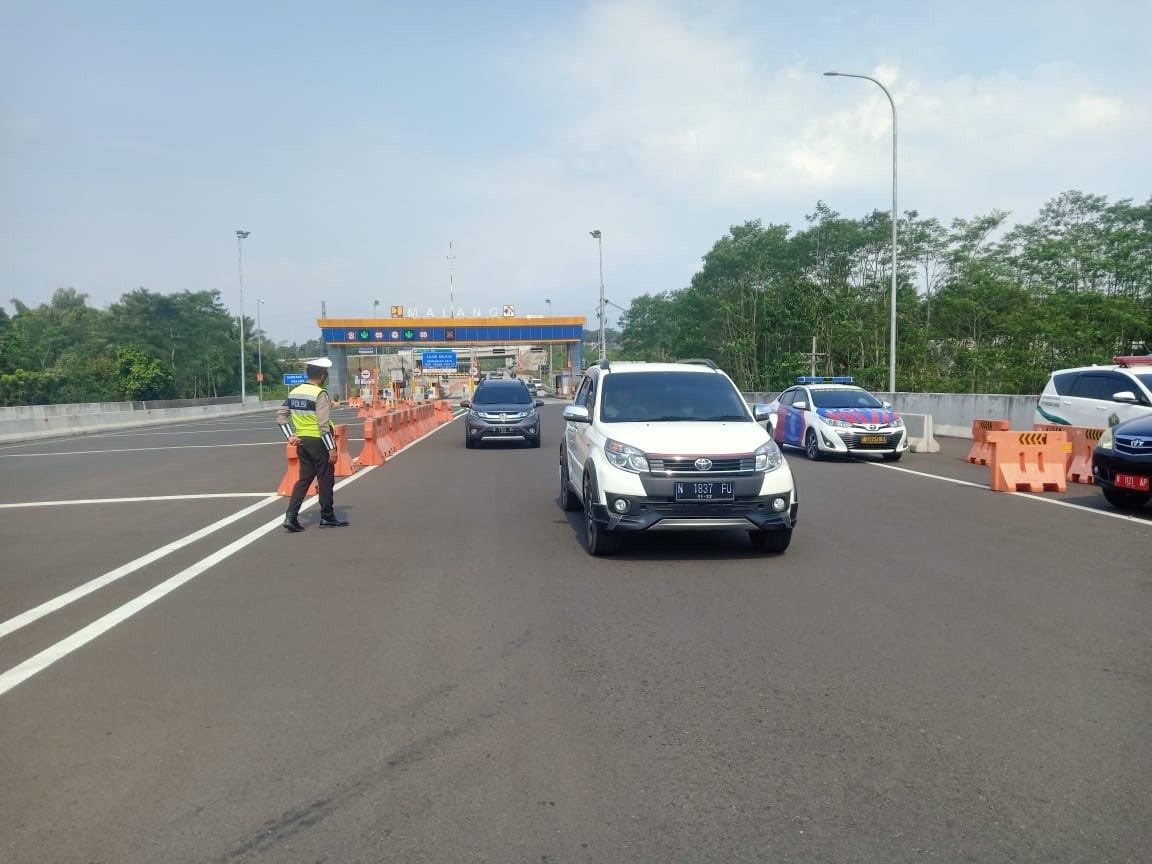 Petugas kepolisian saat mengatur arus lalu-lintas di Exit Tol Madyopuro, Malang. (Foto: Lalu Theo/Ngopibareng.id)