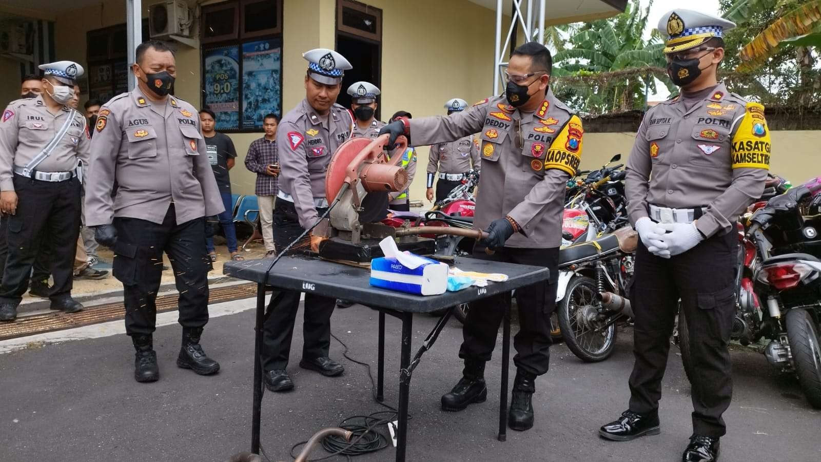 Kapolresta Banyuwangi Kombes Pol Dedy Foury Millewa memotong knalpot brong dengan gerinda. (Foto: Muh Hujaini/Ngopibareng.id)