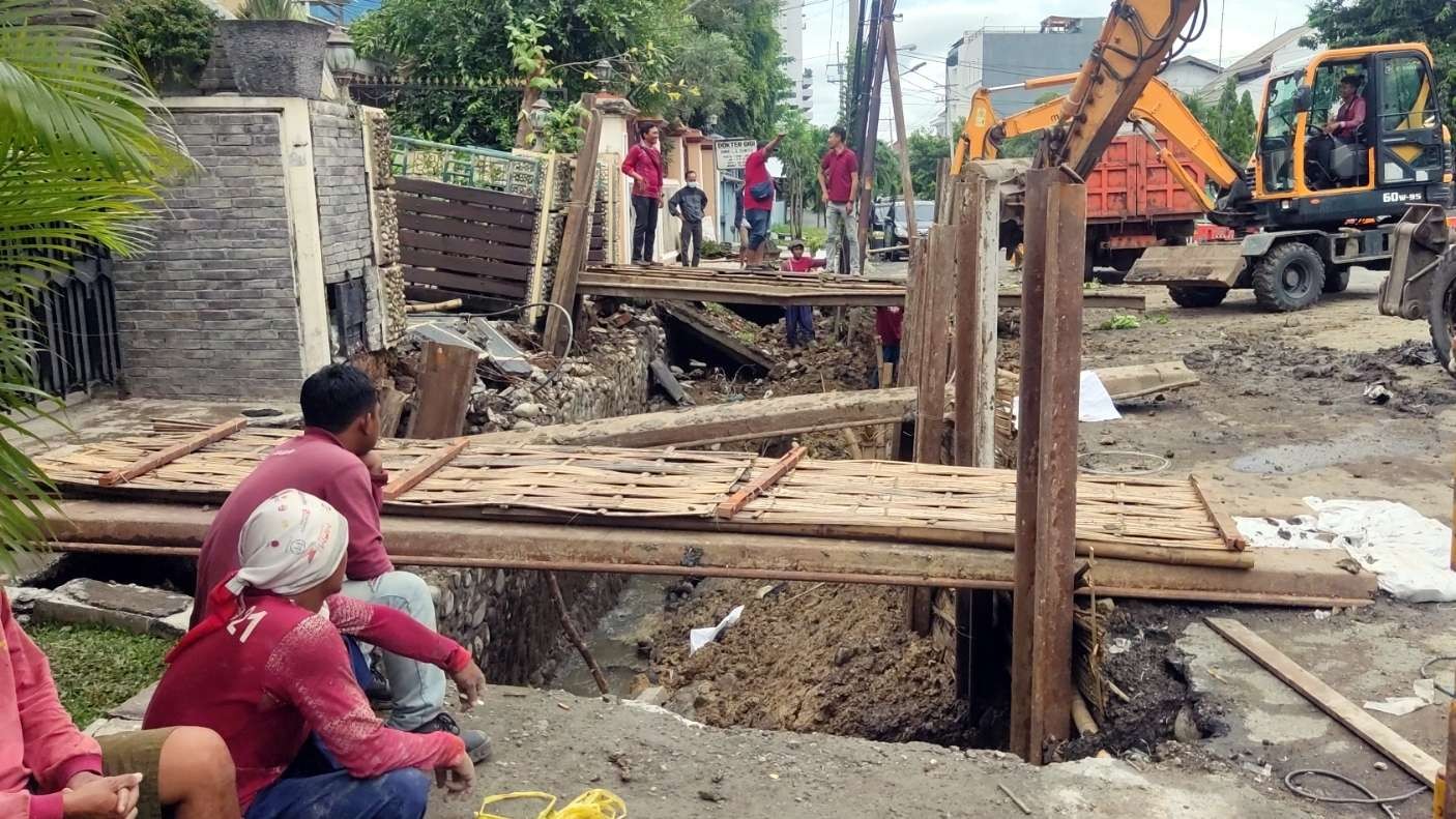 Petugas melakukan pengerjaan di lokasi kejadian jalan ambles di Jalan Pakis Argosari, Surabaya, Sabtu 31 Desember 2022. (Foto: Fariz Yarbo/Ngopibareng.id)