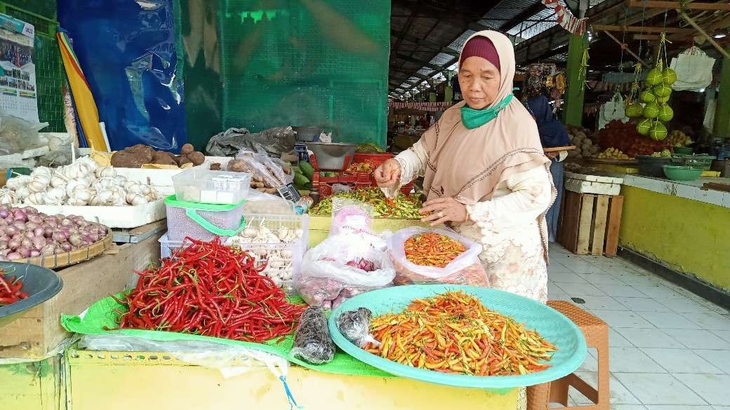 Pedagang kebutuhan pokok di pasar baru Tuban sedang melayani pembeli (Foto: Khoirul Huda/Ngopibareng.id)