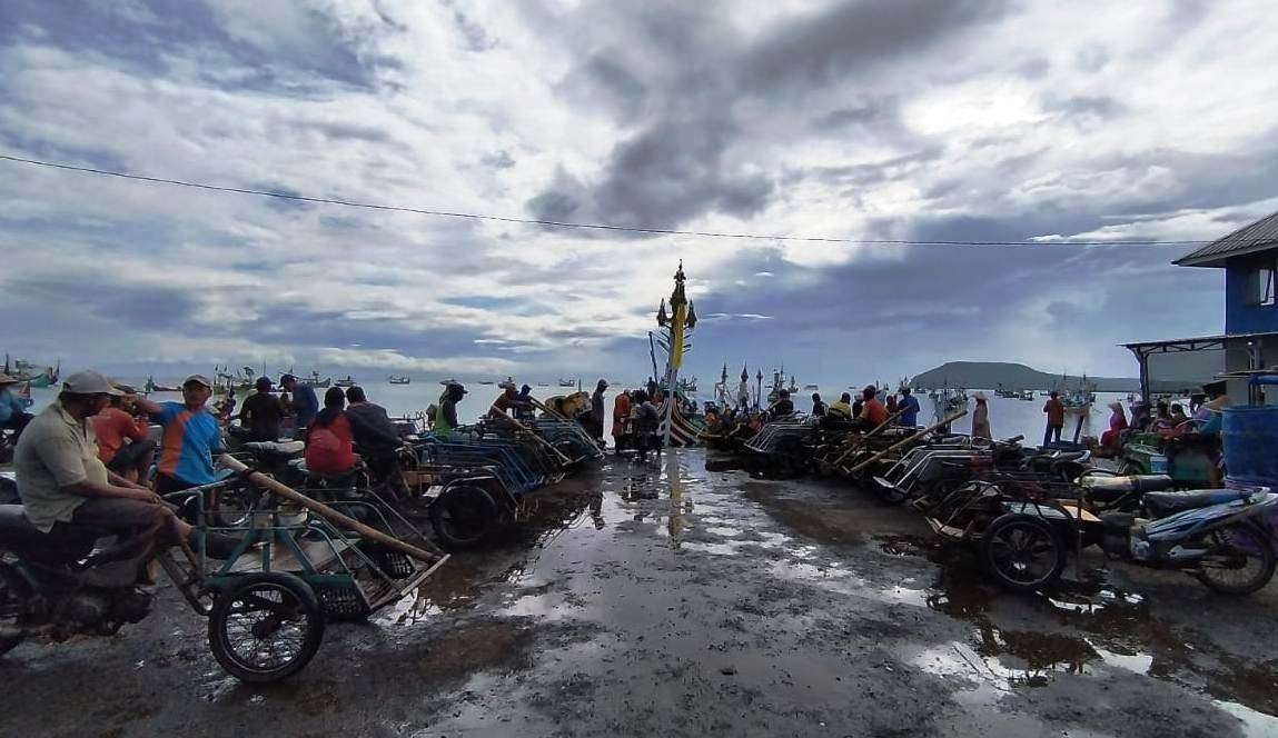 Puluhan pedagang ikan sedang menunggu hasil tangkapan ikan dari kapal slerek. (foto: Muh Hujaini/Ngopibareng.id)