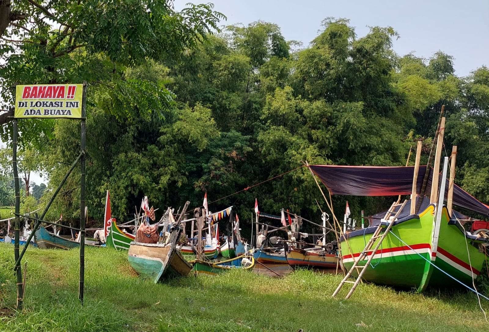 Pihak Desa Bayeman, Kecamatan Tongas, Kabupaten Probolinggo memasang rambu peringatan di tepi sungai “Bahaya!! di Lokasi Ini Ada Buaya.” (Foto: Ikhsan Mahmudi/Ngopibareng.id)