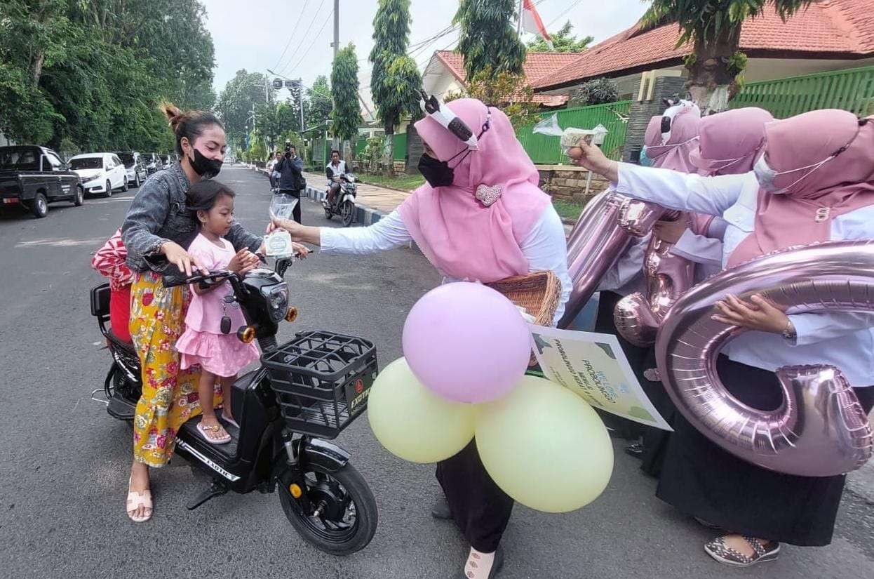 Pihak Dinas dan P2KB Kota Probolinggo sedang membagikan telur dan susu kepada pengguna jalan. (Foto: Ikhsan Mahmudi/Ngopibareng.id)