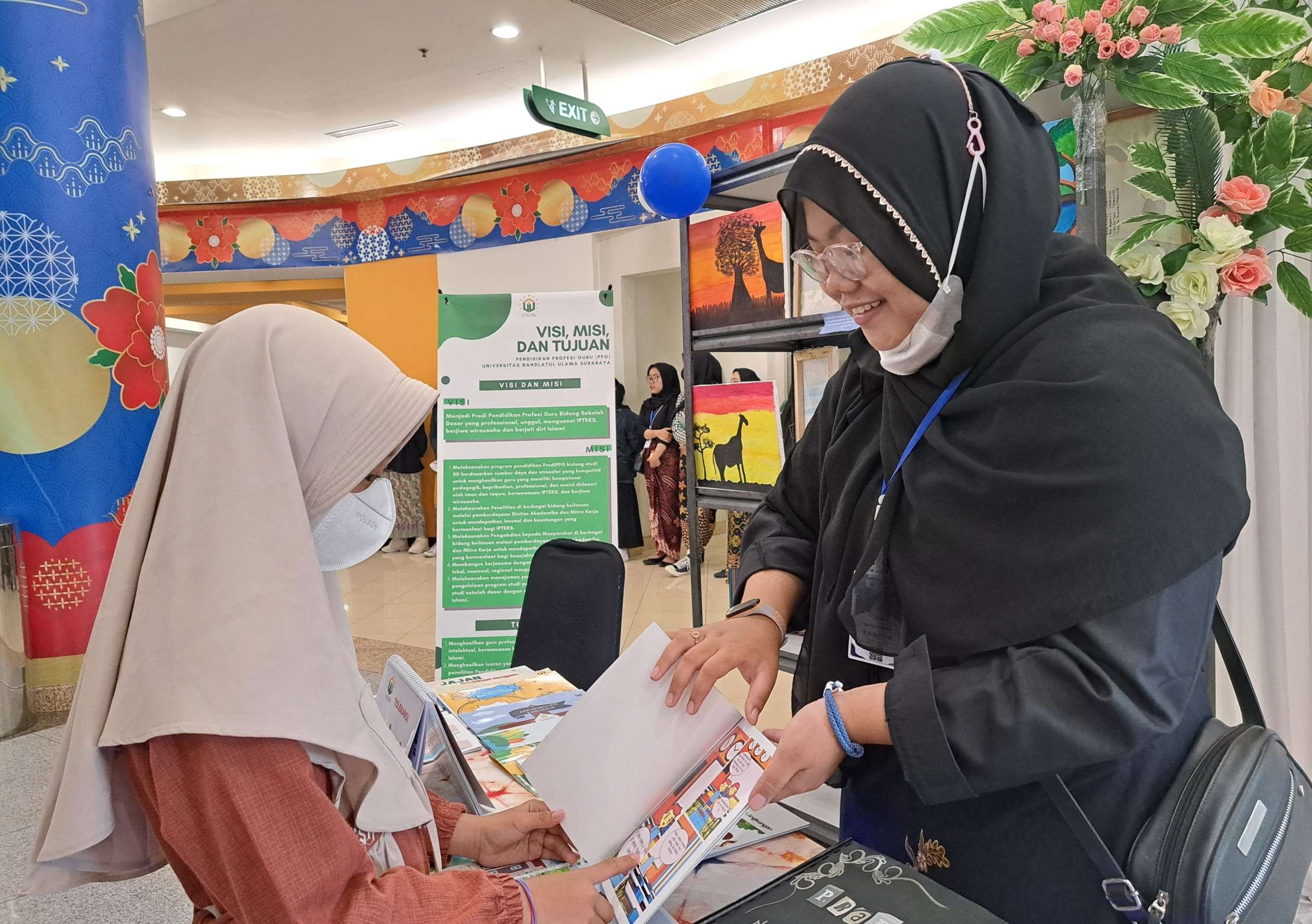 Salah satu mahasiswi PGSD, Marsya Rosyidah saat menunjukkan komik karyanya kepada salah satu siswa SD yang datang di boothnya. (Foto: Pita Sari/Ngopibareng.id)