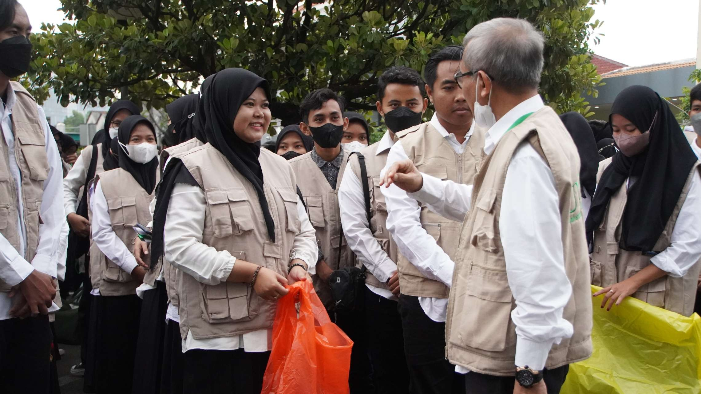 Rektor Unusa, Prof Jazidie menyerahkan kantong plastik yang akan digunakan untuk memungut sampah di Harlah Satu Abad NU. (Foto: Pita Sari/Ngopibareng.id)