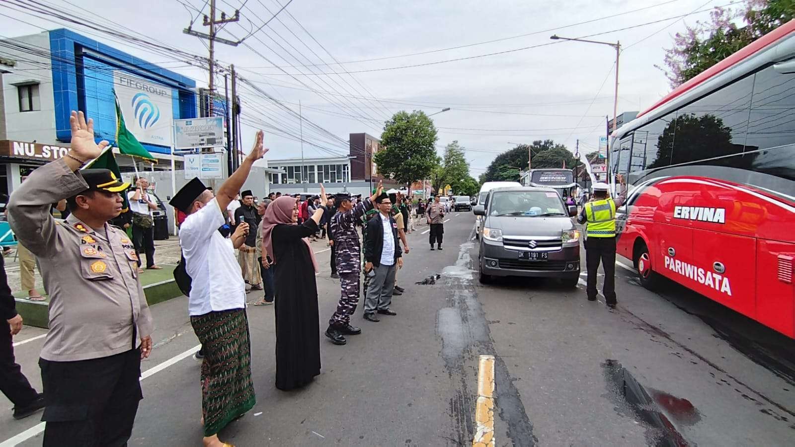 Wakapolresta Banyuwangi AKBP Dewa Putu Eka Darmawan bersama Ketua PCNU Banyuwangi KH Ali Makki Zaini, dan Bupati Ipuk Fiestiandani melepas rombongan warga NU ke Sidoarjo. (Foto: Muh Hujaini/Ngopibareng.id)