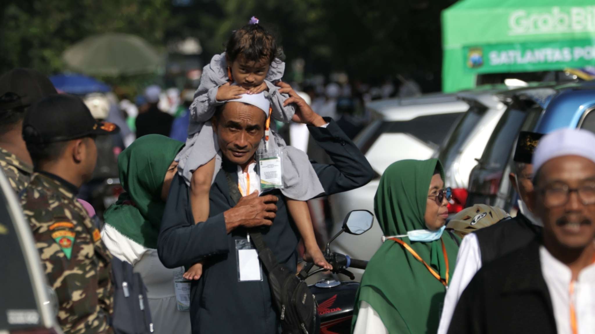 Sejumlah warga jalan kaki dari Jalan Mayjend Sungkono menuju arena Harlah 1 Abad NU di Stadion Gelora Delta, Sidoarjo, Selasa 7 Januari 2023. (Foto: Fariz Yarbo/Ngopibareng.id)