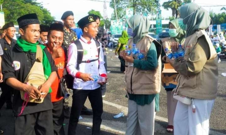 Relawan LDII membagikan air mineral di puncak resepsi Satu Abad NU di Sidoarjo. Ini bukti ukhuwah islamiyah solid. (Foto: Media Center LDII)