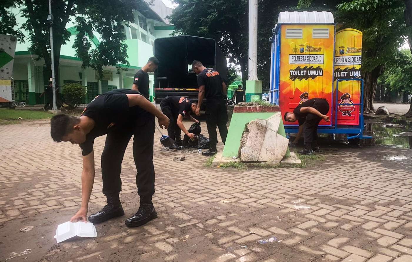 Polisi bekerja sama membersihkan kawasan Gor Sidoarjo pasca harlah (foto : Aini/Ngopibareng.id)