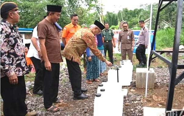 Bupati Bondowoso Salwa Arifin mencoba air bersih sumur bor dibangun BPBD di Desa Purnama Kecamatan Tegalampel.(Foto: Guido Saphan/Ngopibareng.id)