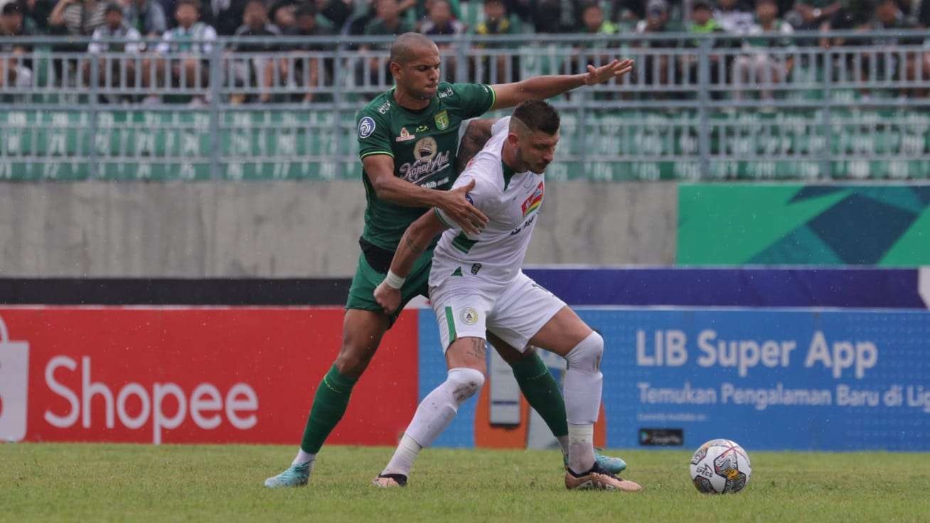 Stopper Persebaya, Leo Lelis (hijau) menjaga ketat Striker PSS Sleman Yehven Bhokashvili dalam laga di Stadion Gelora Joko Samudro, Gresik, Senin 13 Februari 2023. (Foto: Fariz Yarbo/Ngopibareng.id)